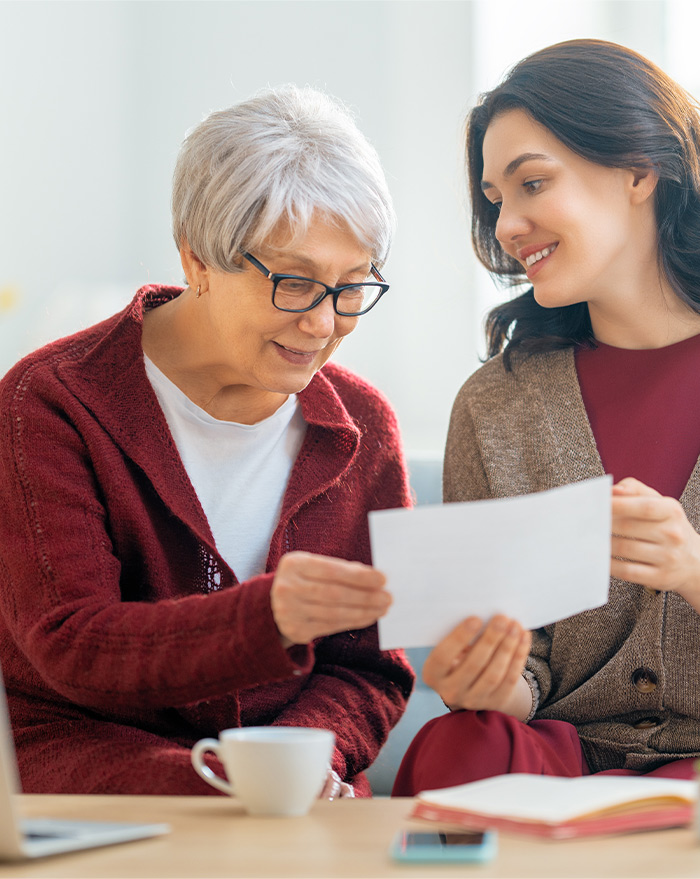 header image showing elderly woman receiving help reviewing a document